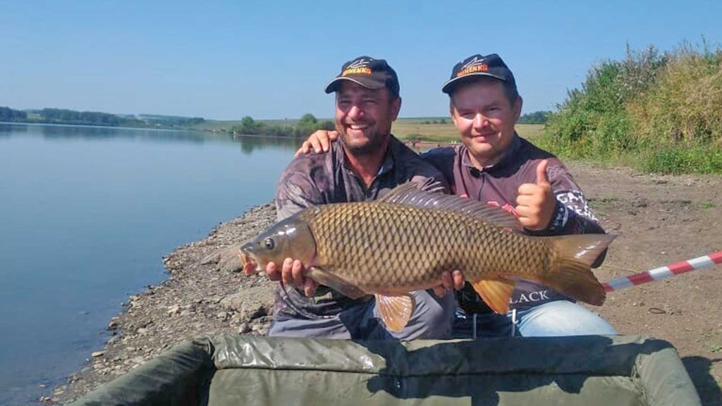 мужчины фотографируются с крупной рыбой