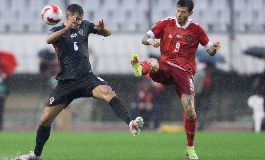 Не просто играть при таких погодных условиях. Деян Ловрен против Федора Смолова. Фото: Reuters